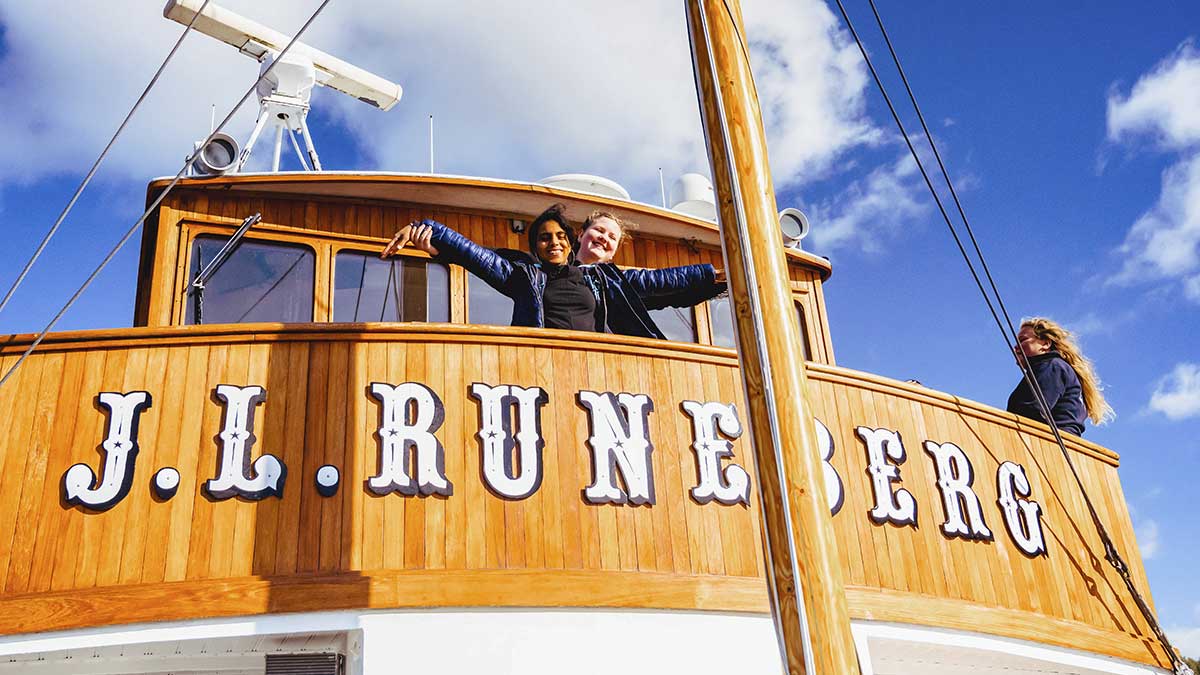 Iloisia matkailijoita Runeberg laivan komantosillalla.