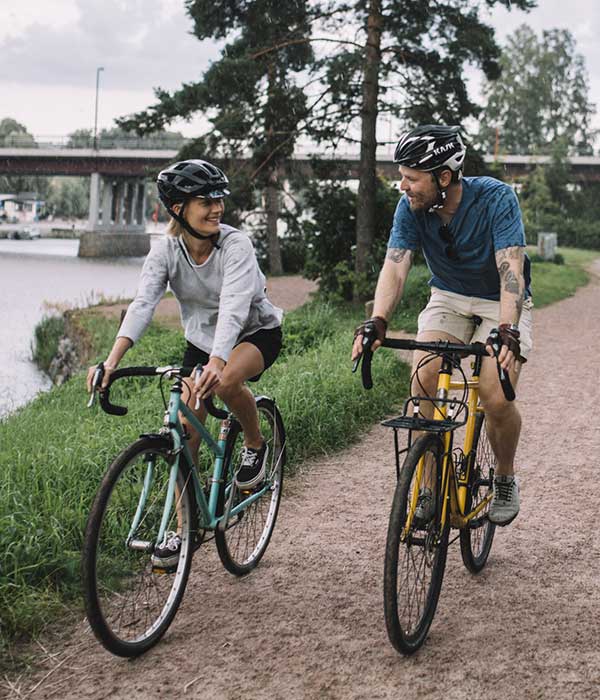 A picture of a bicycling couple in Porvoo, next to the riverside, by Sami Heiskanen.